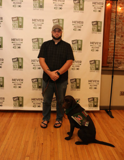 Veteran with brown lab service dog at Got Your Six Support Dogs graduation ceremony