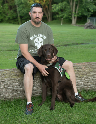 Seal team member with chocolate lab support service dog