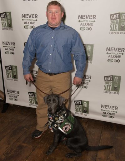 Veteran with gray lab service dog at Got Your Six Support Dogs graduation ceremony